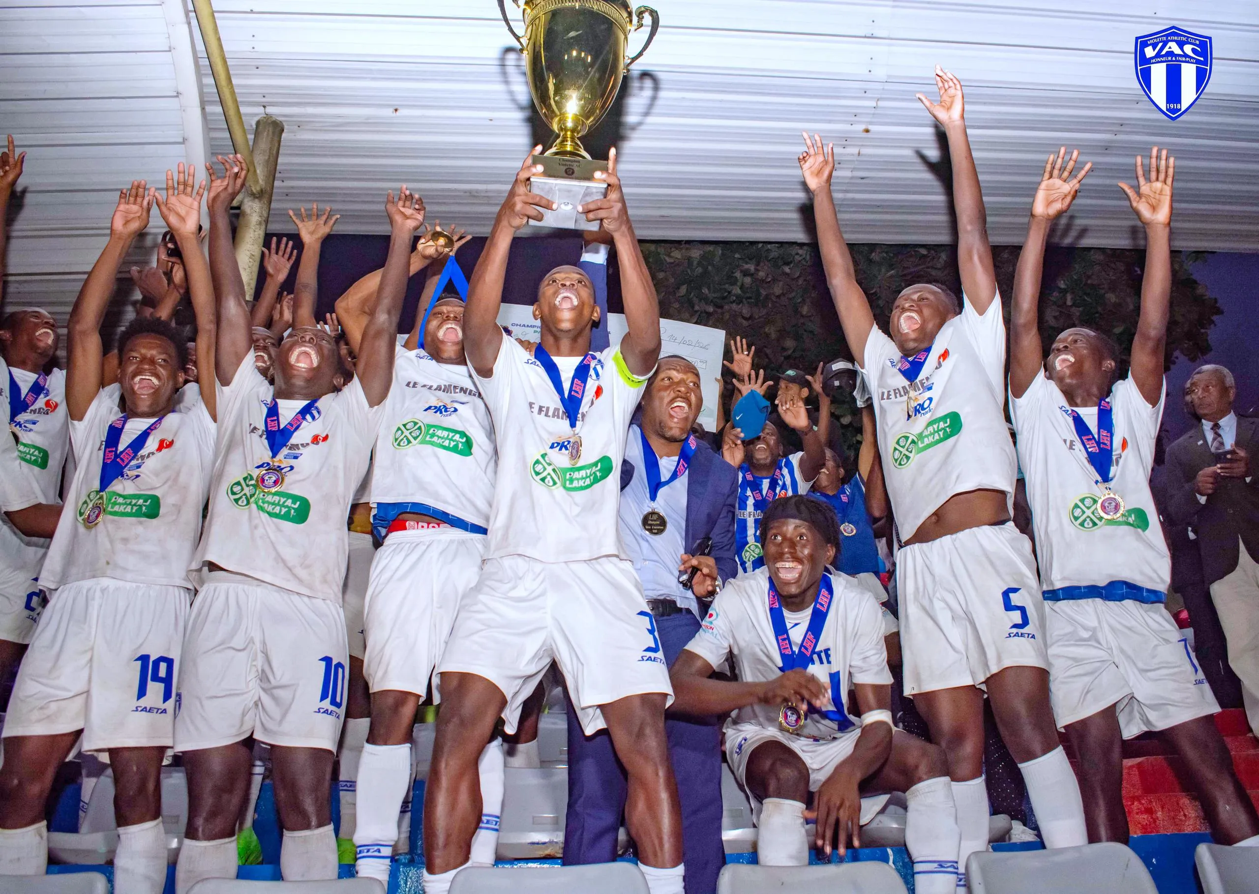 Les joueurs du Violette AC célèbrent le titre de champion en tenue blanche