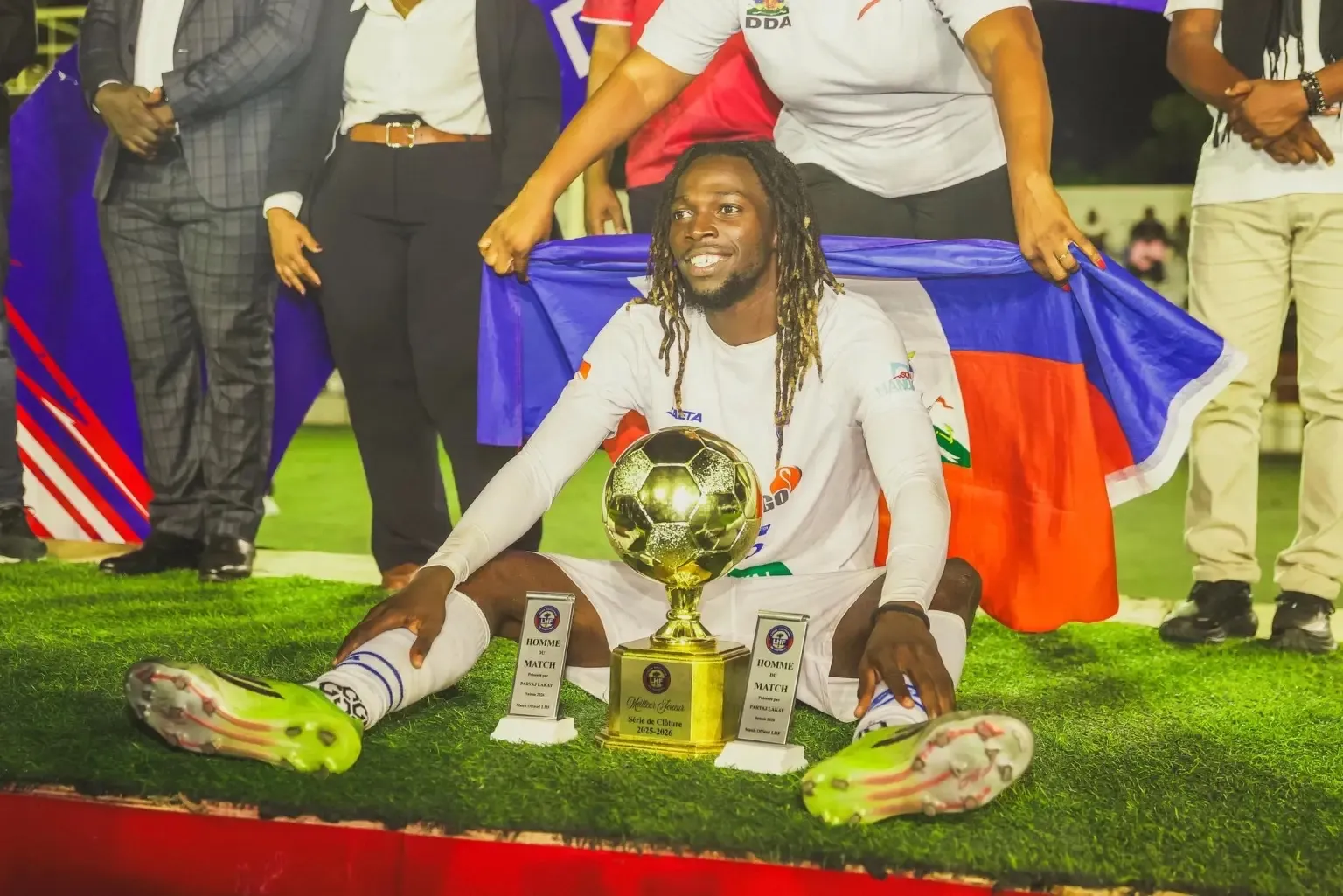 Woodensky Pierre avec le trophée et le drapeau haïtien